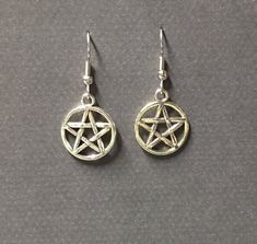 Handmade silver plated pentagram charm earring. A classic for every dark lady. Choose your metal type ear hook and I will make one just for you. Product details Pentagram charm is silver plated; Your choice of ear hook, sterling silver or silver plated. nickel free 1 1/2 inches long total VISIT MY SHOPS HERE * http://www.etsy.com/shop/HappyCatHouse * http://www.Etsy.com/shop/AnEnchantingCreature CONNECT * http://www.facebook.com/EnchantingCreature * https://instagram.com/enchantingcreature * htt Gothic Star-shaped Pierced Earrings, Gothic Silver Star Earrings, Silver Star Gothic Earrings, Silver Witchy Earrings, Gothic Star-shaped Metal Earrings, Gothic Star Shaped Metal Earrings, Silver Witchy Pierced Earrings, Nickel Free Sterling Silver Witchy Earrings, Nickel-free Sterling Silver Witchy Earrings