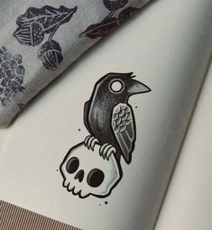 a black bird sitting on top of a skull next to a blue and white tie