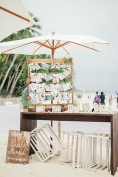 a table with pictures and an umbrella on the beach