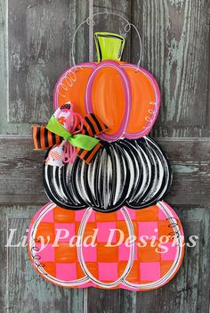 an orange and black pumpkin shaped door hanger