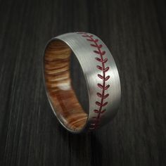 a baseball ring with red stitching inlays the center on a wooden surface