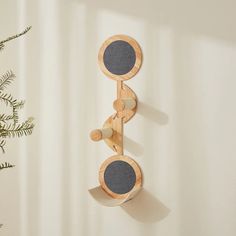 a wooden wall mounted speaker next to a potted plant on a white wall in front of a curtain