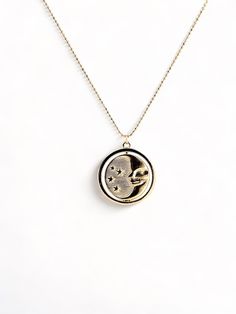 A gold rotating necklace which features the face of the sun on one side and the face of the moon on the other. Comes in 2 sizes. Small charm is 1” wide and hangs from a 16” chain Big charm is 1.5” wide and hangs from a 21” chain Moon Phase Medallion Amulet Jewelry, Moon Phase Medallion Necklace In Amulet Style, Moon Phase Medallion Necklaces Styled As Amulets, Celestial Moon Phase Charm Necklace With Round Pendant, Celestial Charm Necklace With Moon Phase Pendant, Celestial Moon Phase Round Pendant Necklace, Celestial Medallion Necklace With Moon Charm, Celestial Moon Phase Medallion Necklace, Brass Moon Charm Round Pendant Necklace