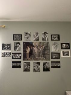 a group of people standing in front of a wall with pictures on it