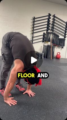 a man doing a handstand on the ground in a gym