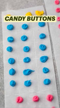 blue and yellow plastic buttons sitting on top of a piece of paper next to each other