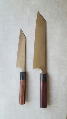 two knives are mounted on the wall next to each other