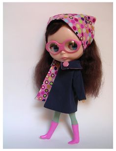 a doll with glasses and a hat on it's head is standing next to a wall