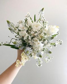 a bouquet of white flowers in someone's hand