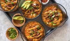 several bowls of mexican food on a tray