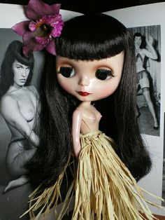 a doll with long black hair and a flower in her hair