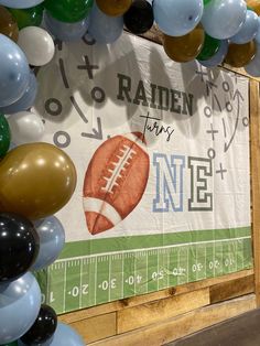 balloons and footballs are hanging on the wall in front of a sign that says radien for nine