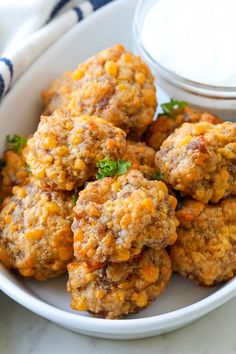 a white plate topped with meatballs next to a bowl of ranch dressing