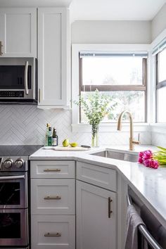 a kitchen with white cabinets and stainless steel appliances