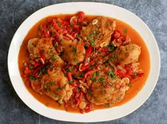 a white plate topped with meat covered in red sauce