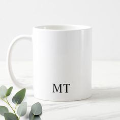 a white coffee mug with the word mt on it