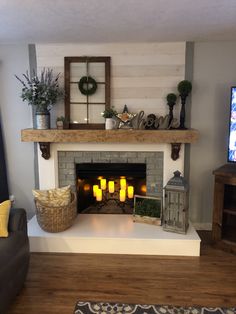 a living room filled with furniture and a fire place covered in candles next to a flat screen tv