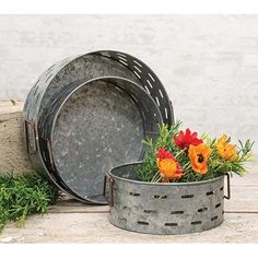 two metal buckets with flowers in them