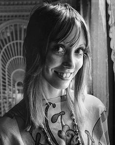 a black and white photo of a woman with long hair wearing a shirt that has flowers on it