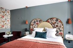 a large bed sitting in a bedroom next to a table with flowers on top of it