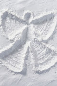 an angel made out of snow on the ground