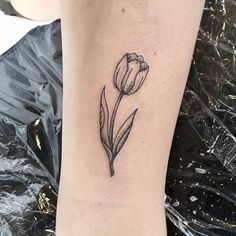 a small black and white tulip tattoo on the right side of the leg,