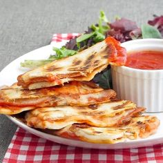 some food is on a white plate with a red and white checkered tablecloth