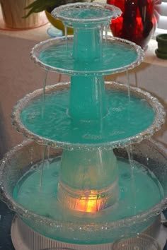 three tiered glass water fountain with lit candles