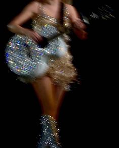 a woman is dressed in silver and holding a frisbee