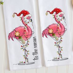 two towels with flamingos wearing santa hats and holding candy canes on them next to a wooden spoon