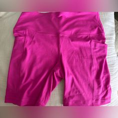 a pink shorts laying on top of a bed