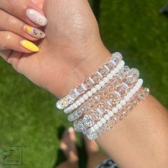 Adorn your arms with this stunning combination of white, crystal and gold-toned bracelets. Crafted to evoke a timeless elegance, these precious accessories are the perfect blend of minimalist sophistication and classic luxury. Material :* 4mm gold plated beads * charms * crystal beads *4mm matte beads • Bracelets are custom-crafted according to size; if the desired size isn't listed below, please contact me for assistance. • Processing Time is an estimated 3-5 business days (does not include wee Dainty White Charm Bracelet For Everyday, White Pearl Stretch Bracelet Dainty Style, Dainty White Round Charm Bracelet, White Gold Beads Bracelet, Pearl White Crystal Bracelet As Gift, Pearl White Crystal Bracelet Gift, Pearl White Crystal Bracelet For Gift, White Party Bracelets With Rhinestones, White Rhinestone Bracelets For Party