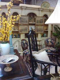 a living room filled with lots of furniture and flowers in vases on the table