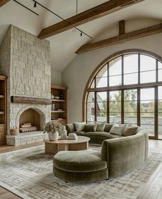 a living room filled with lots of furniture and a fire place in front of a large window