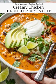 a bowl of creamy chicken enchilada soup with avocado and sour cream