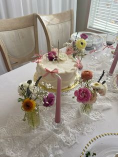 a table topped with a white cake covered in flowers