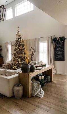 a living room filled with furniture and a christmas tree in the middle of the room