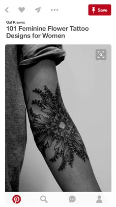 a black and white photo of a person's arm with flowers on the wrist