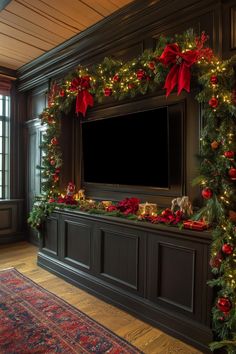 a christmas decorated entertainment center with lights and garland on the wall, along with presents