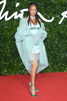 a woman in a blue dress and heels on the red carpet at an awards event