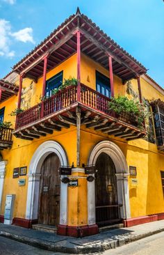 an old yellow building with red trim and balconies