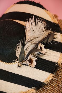 Get ready to turn heads with THE SICILY SUN HAT! This must-have accessory features a chic straw floppy design with playful black painted stripes. A gold chain band adds a touch of glamour, while the white and black feathers and flowers combo adds a fun and unique twist. Keep cool in style with this quirky and eye-catching hat. This hat is ONE OF A KIND, created by our owner Stephanie. To receive item quicker, expedited shipping is available at checkout. Black Summer Hat With Feather Trim, Black Summer Hats With Feather Trim, Summer Black Hats With Feather Trim, Beach Hats With Feathers For Spring, Chic Feathered Hats For Spring, Chic Spring Hats With Feathers, Chic Spring Hat With Feathers, Summer Fedora Hat, Painted Stripes