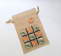 an orange and green tic - tac - toe game on a burlap bag