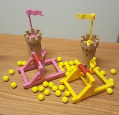 some toys are sitting on a table with yellow and pink balls in front of them