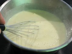 a person mixing batter in a metal bowl with a whisk on the side