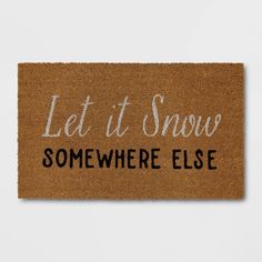 a door mat with the words let it snow somewhere else written on it in white ink