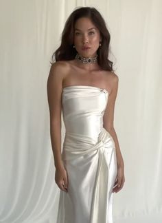 a woman in a white dress posing for the camera