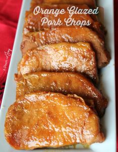 orange glazed pork chops on a white platter with text overlay that says orange glazed pork chops