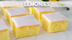 lemon bars with white frosting sitting on top of a counter