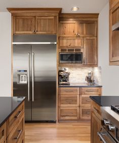 a kitchen with wooden cabinets and stainless steel appliances